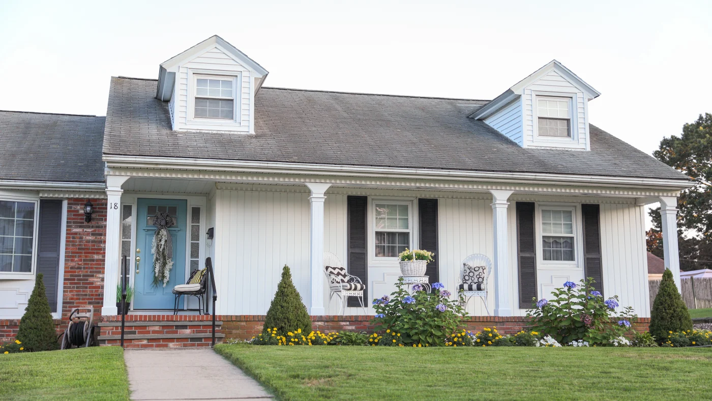 Home with white siding and two roof gables with black shingle roofing