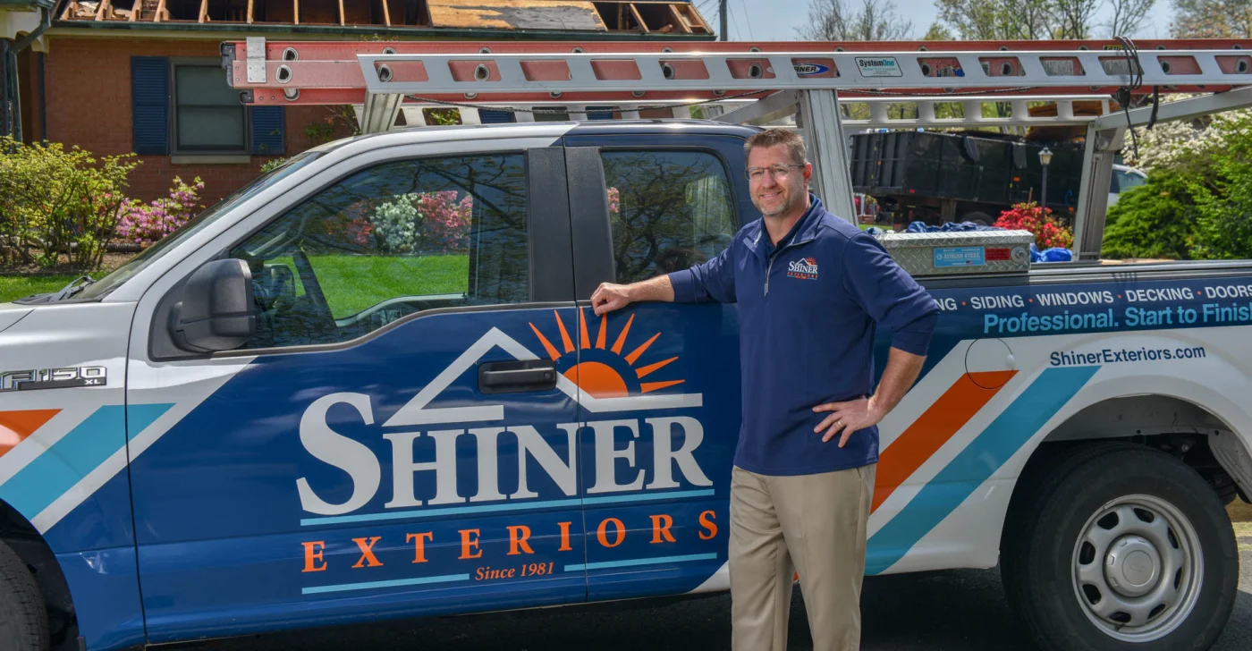 Image of a man standing in front of his Shiner Exteriors service truck