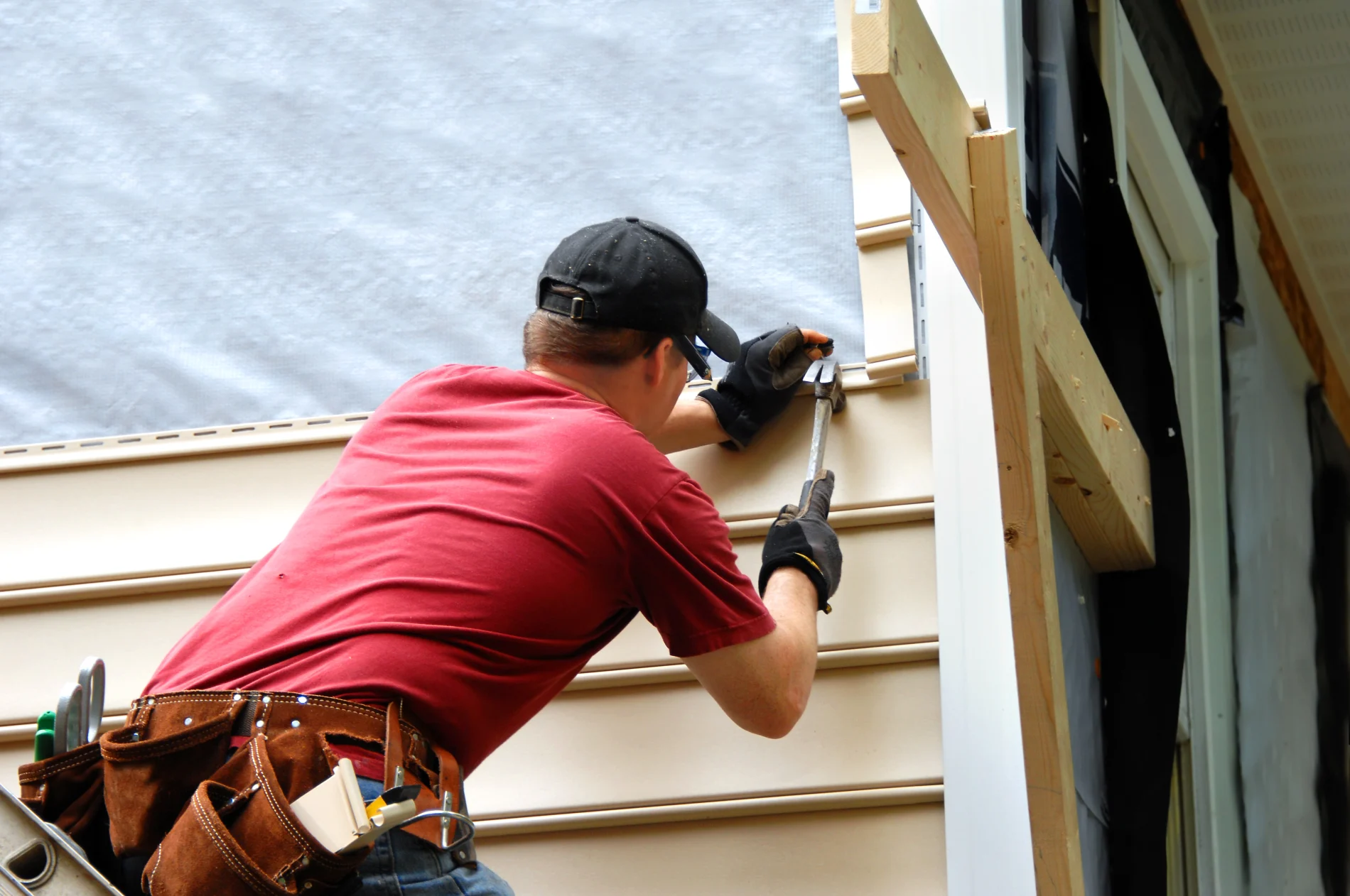 Siding repair in process on damaged vinyl siding panels.